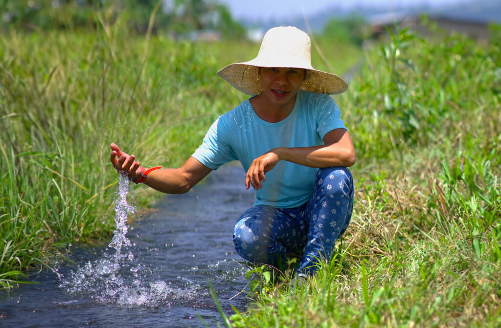 Jaino playfully splashes in the vital irrigation watercourses that sustain Butig's farming community.