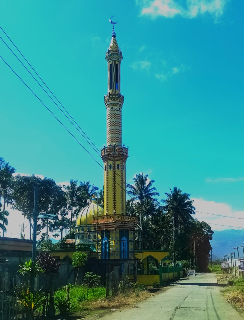 Bathing in golden hues, a close-up view of the bright yellow minaret stands as a striking marker along the access road. 